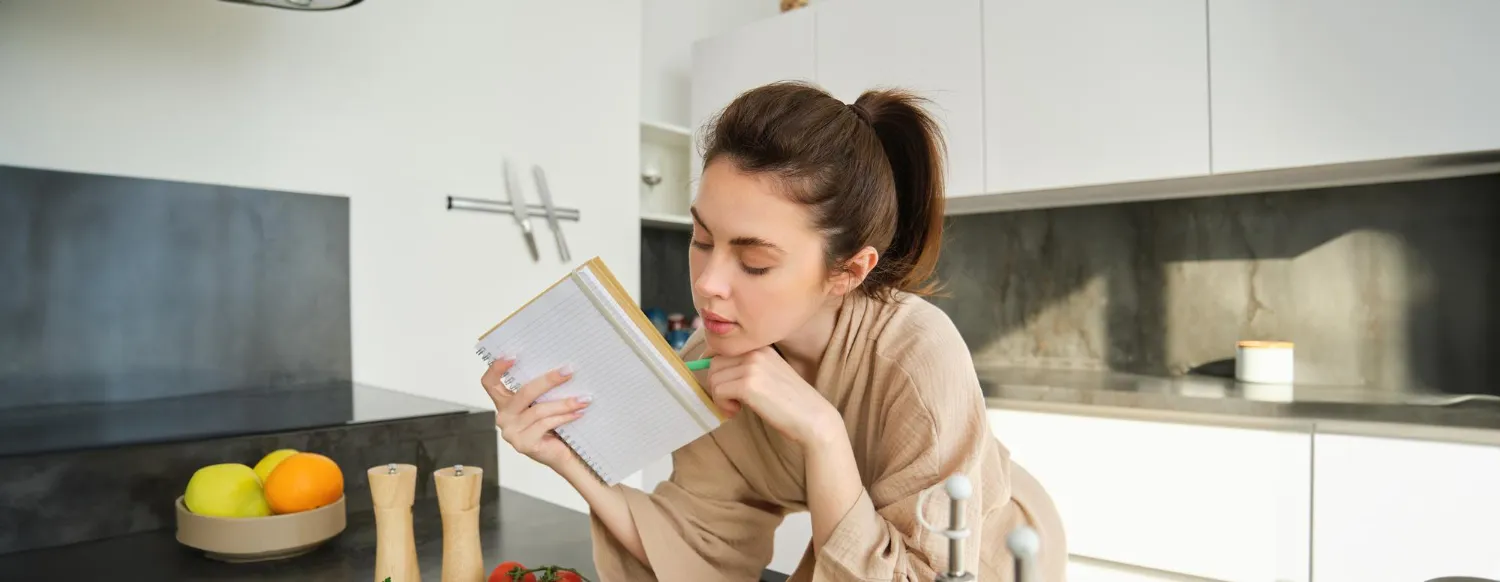Woman reviewing health information at home while managing her medications and overall health.