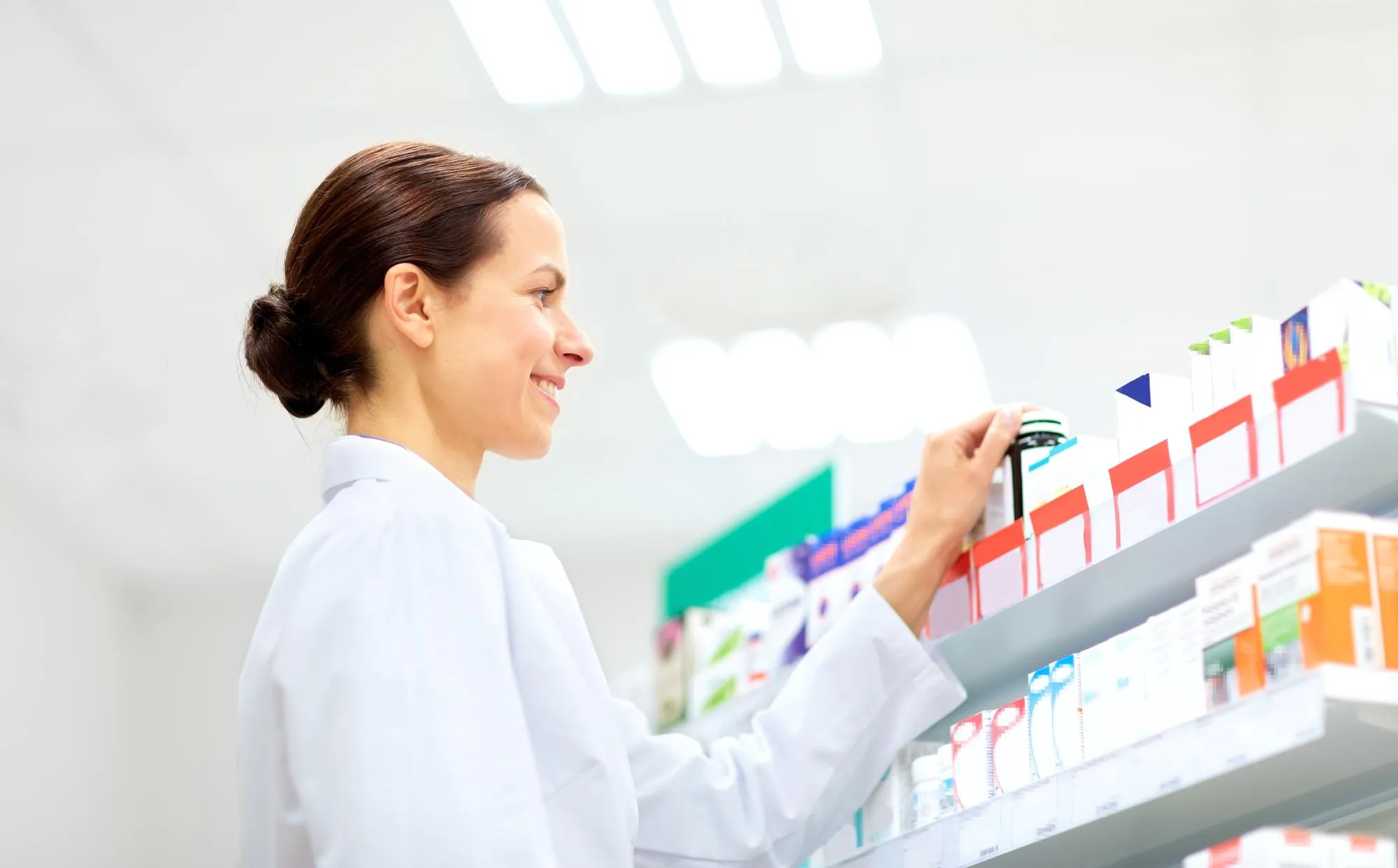 Pharmacist organizing prescription medications on pharmacy shelves, representing professional Pharmacists.