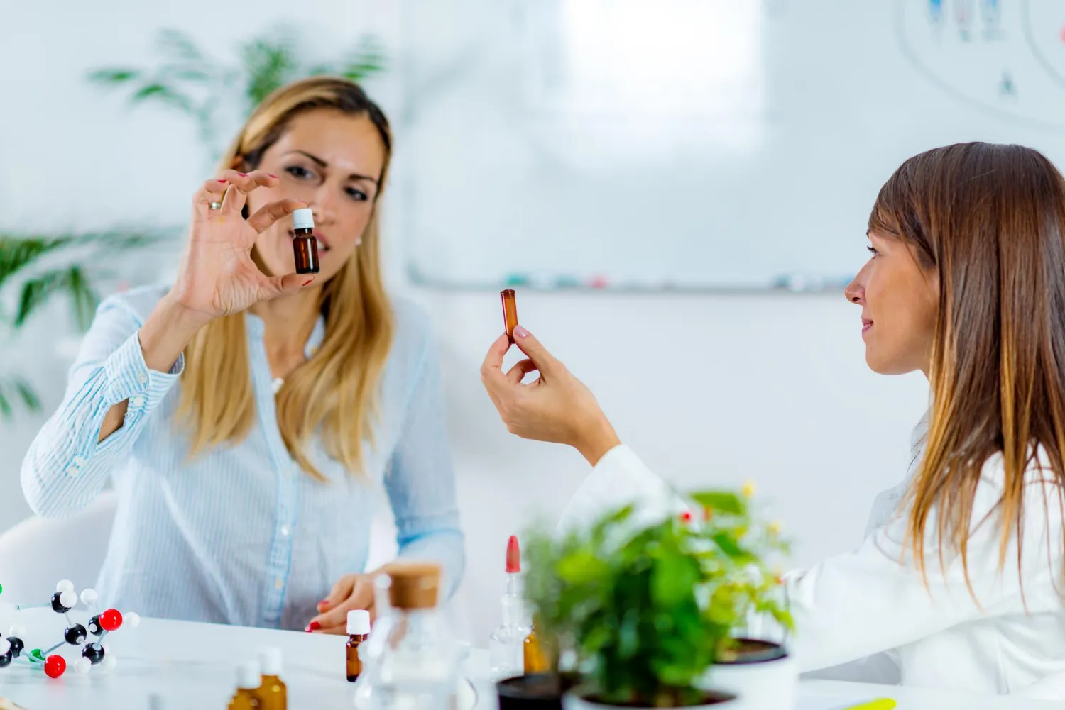 A healthcare professional explaining a small supplement bottle to a patient, illustrating personalized guidance on vitamins and supplements at a Pharmacy in Jacksonville, FL.