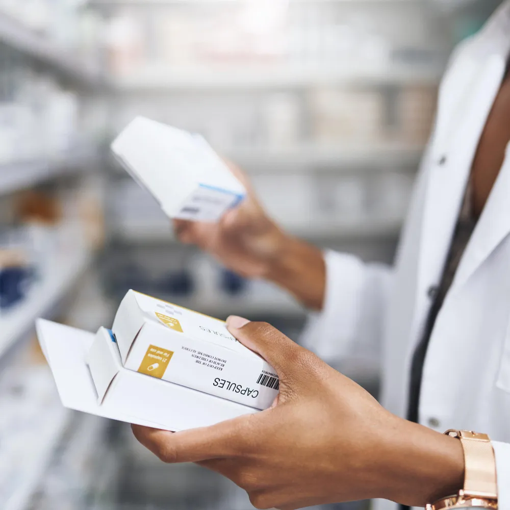 Pharmacist handling prescription medication packages in a Refill Pharmacy in Jacksonville.