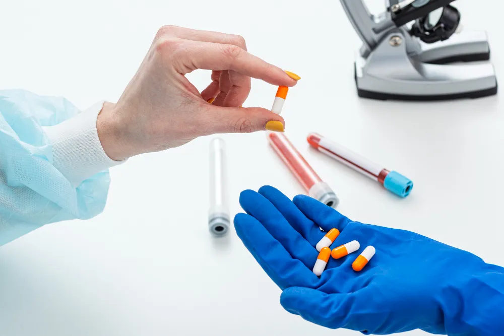 Pharmacist holding medication while discussing treatment for chronic illness with a patient in a pharmacy.