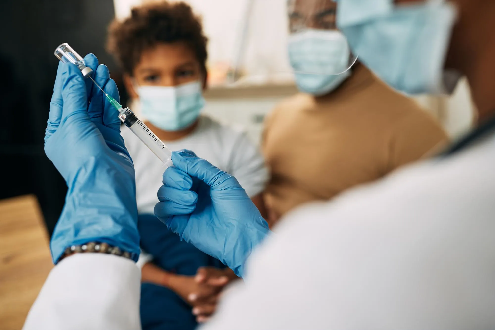 Doctor preparing immunization vaccine dose for adult patient following vaccination schedule