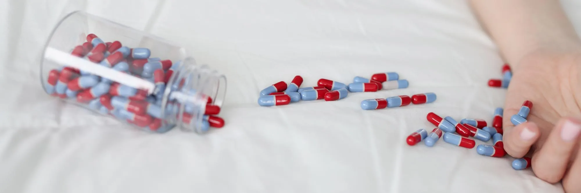 Prescription pills spilled from bottle highlighting importance of medication synchronization and patient medication adherence