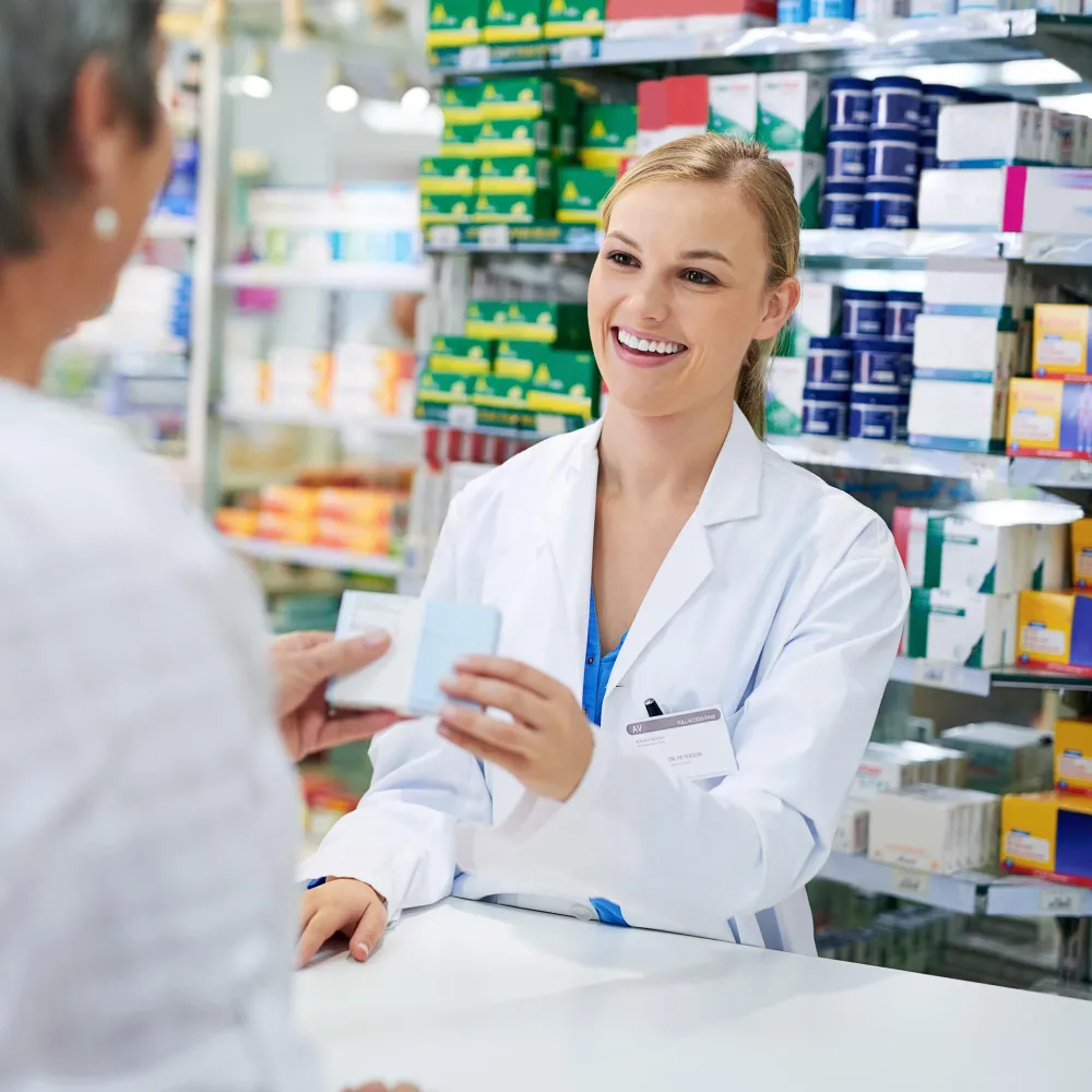 Pharmacist handing medication to a customer at the counter, illustrating medication from pharmacy with personalized service and patient guidance