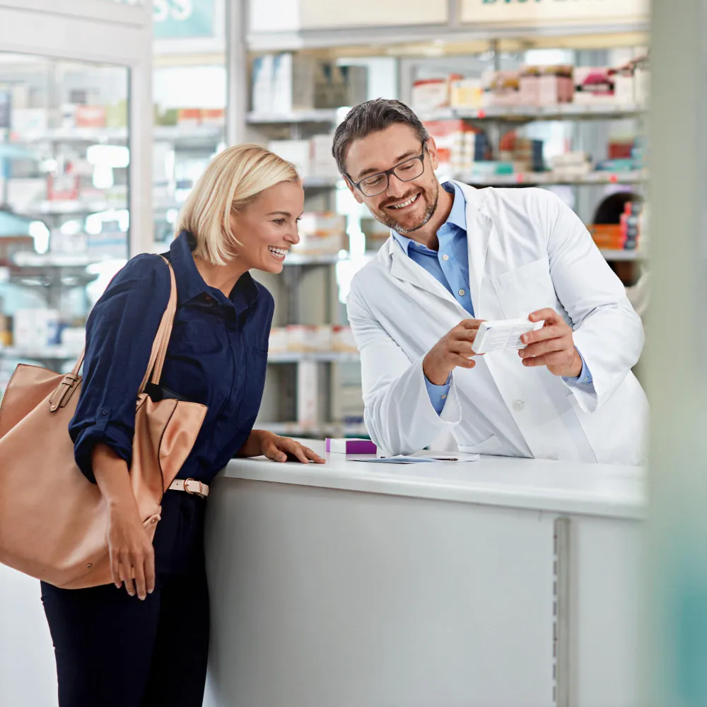 Pharmacist assisting a customer at the counter, highlighting personalized pharmacist consultation services and guidance offered through modern clinical services pharmacy settings