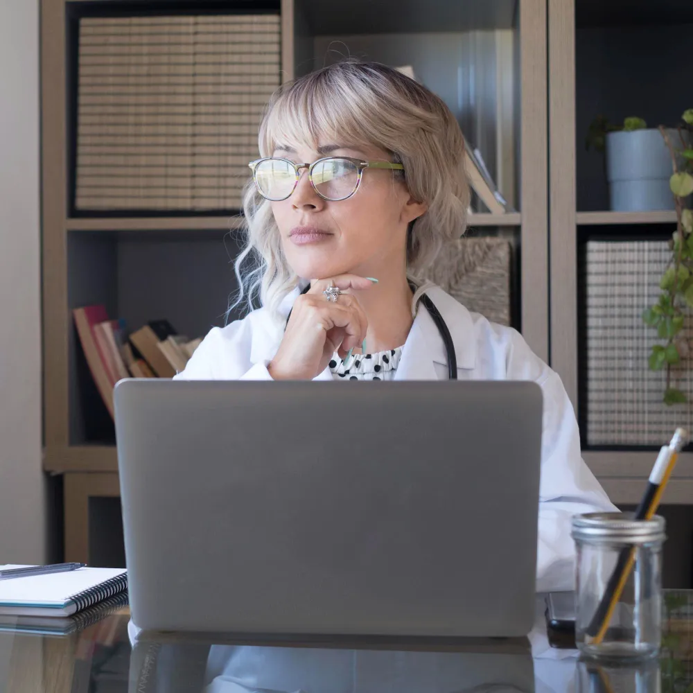 Healthcare professional working on a laptop, representing televisit pharmacy support and efficient virtual doctor appointments for reviewing patient data and managing prescriptions digitally