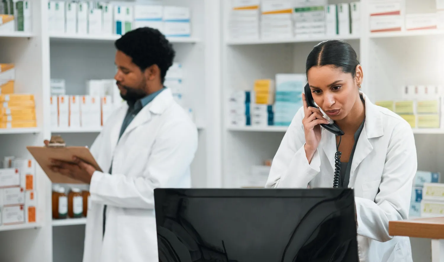 Pharmacist providing pharmacy clinical services and medication management support inside a modern pharmacy clinic