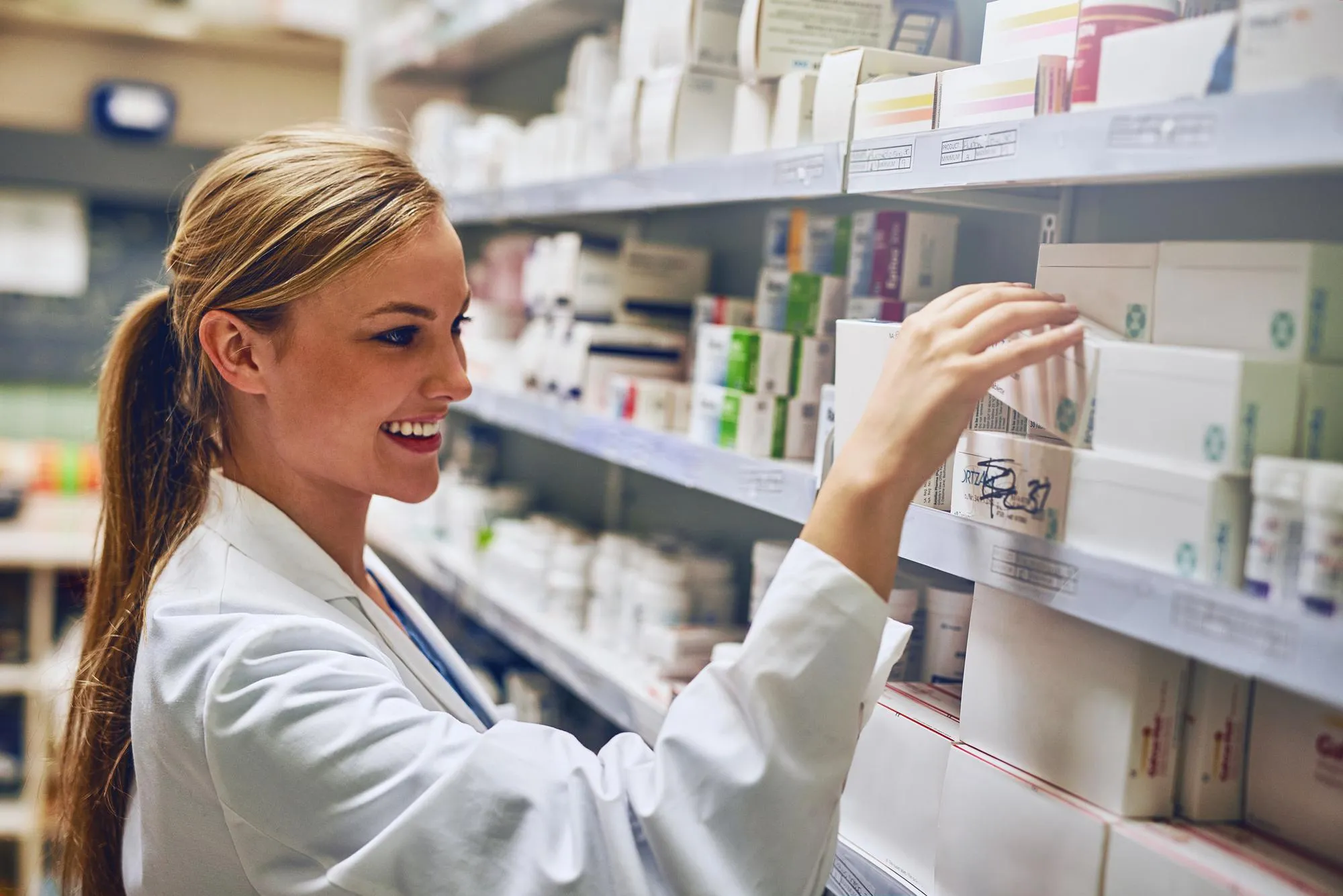 Pharmacist organizing specialty medications on pharmacy shelves, supporting specialty pharmacy services with accurate dispensing and high-complexity medication management.