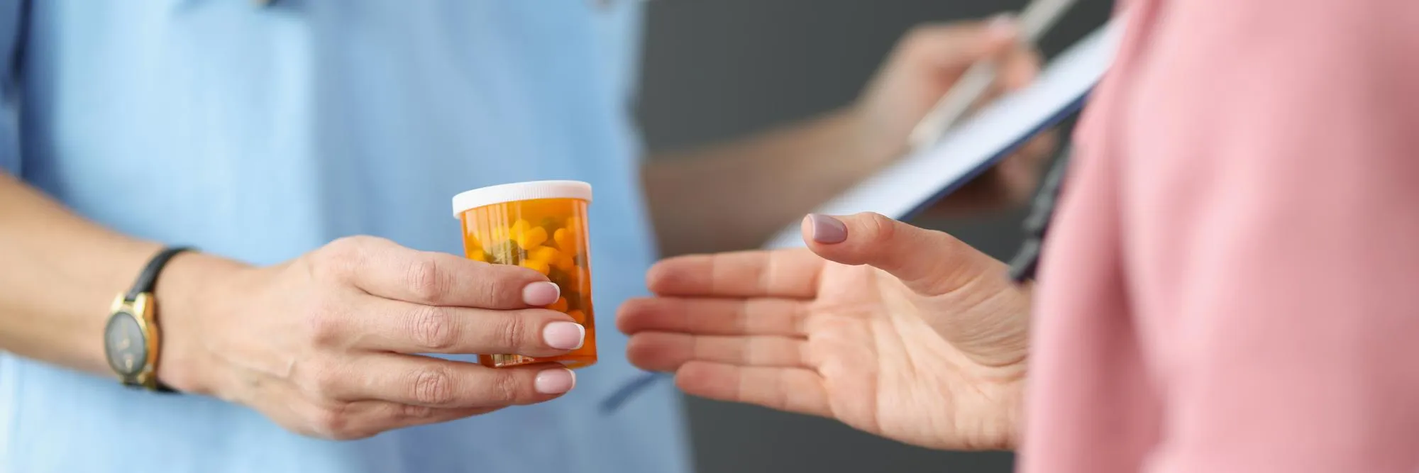 Healthcare professional handing a prescription medication bottle to a patient, representing medication refill services that simplify prescription management.