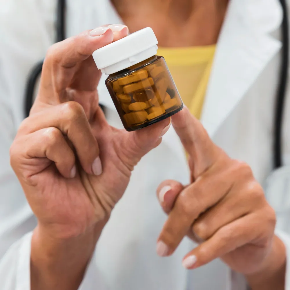 Patient reviewing a prescription medication bottle with a healthcare professional, illustrating prescription synchronization services for coordinated medication refills.