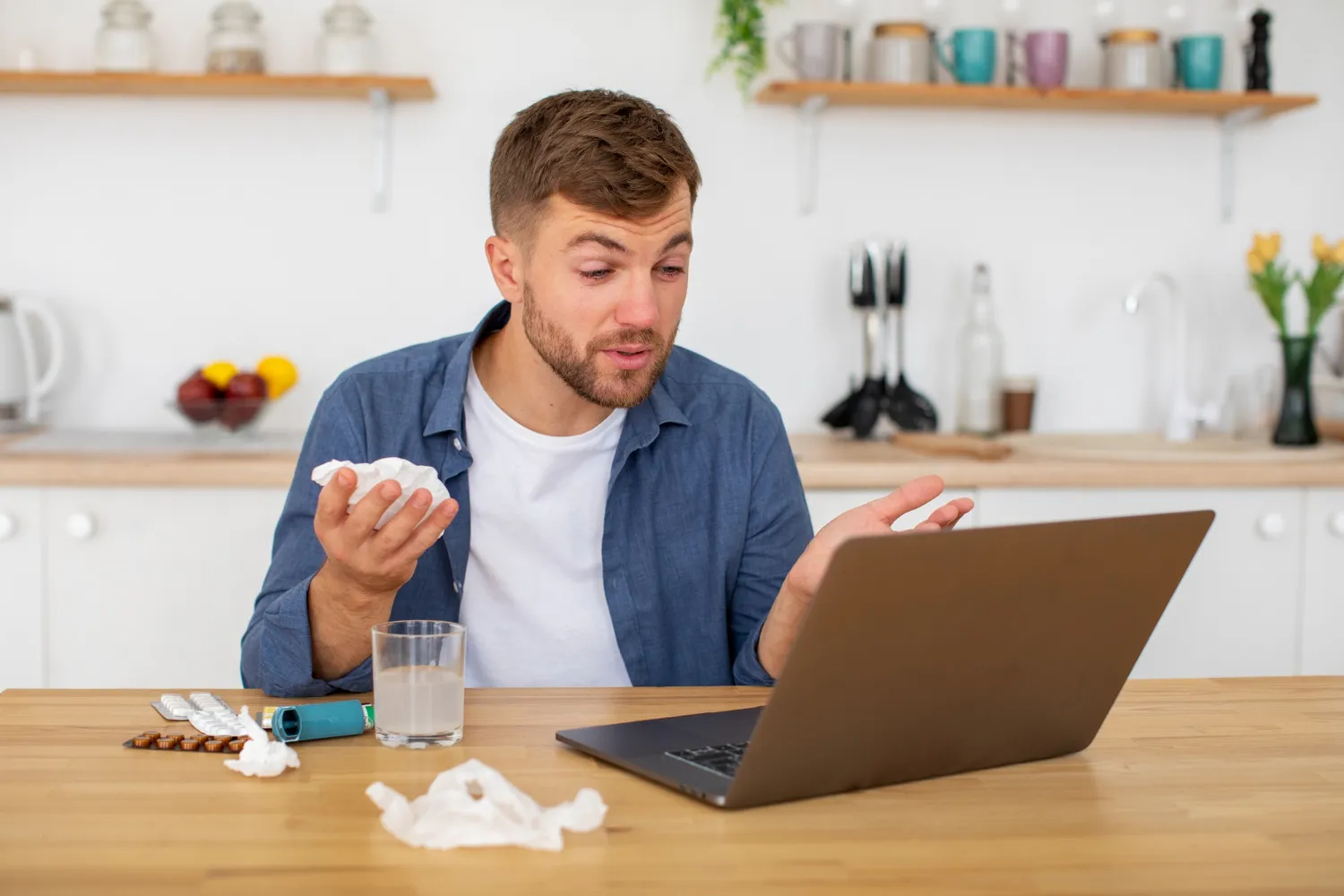Patient managing prescriptions while using a laptop for a medsync program.